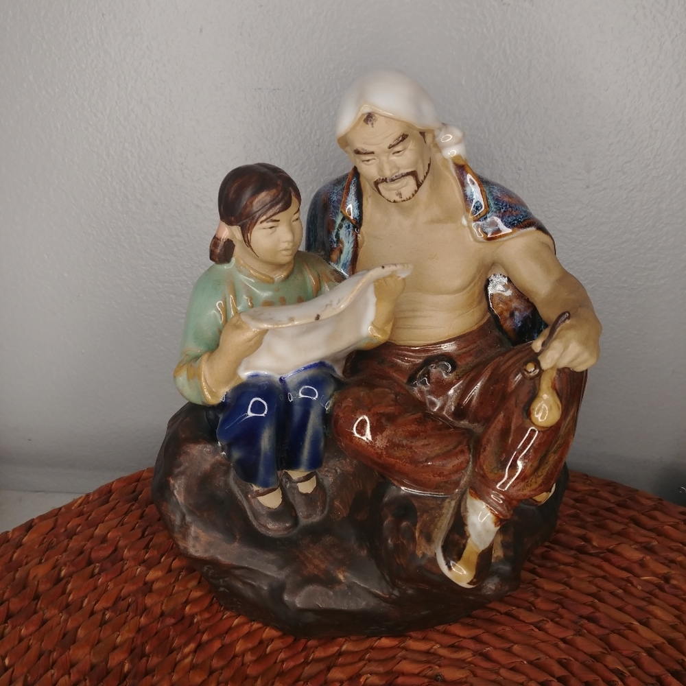 Vintage father and daughter reading mudman statue